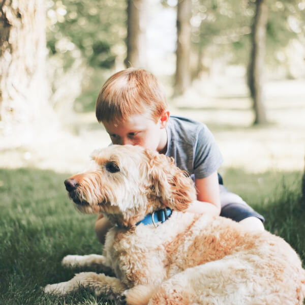 boy and dog relaxing in yard