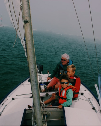 grandfather with grandchildren on a sailboat