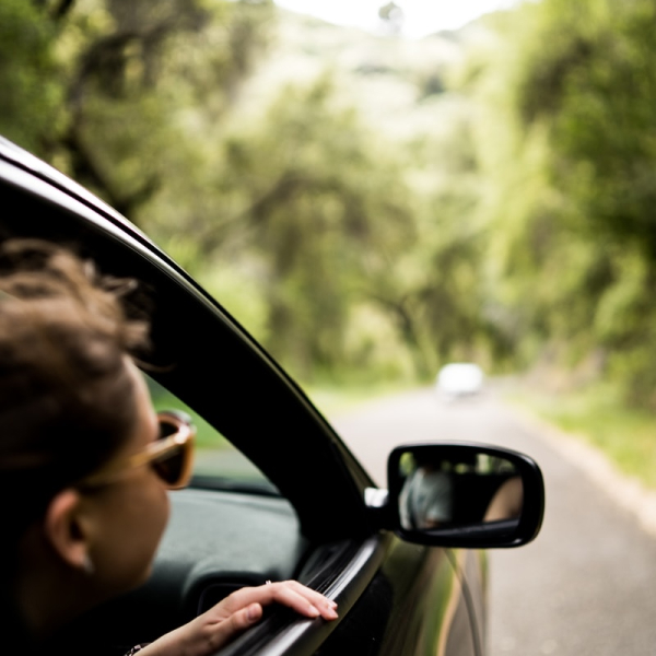 Woman looking out the window of her new vehicle she got with her auto loan