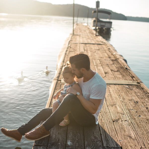 father and daughter sitting on a dock