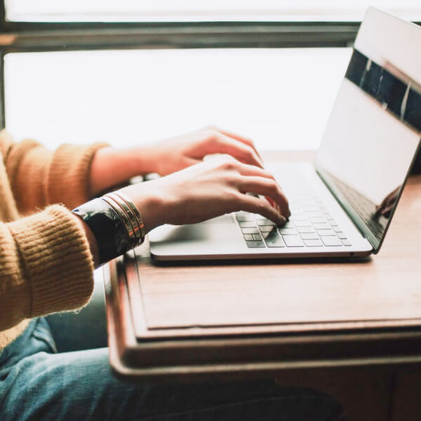 Hands typing on laptop, checking digital bank