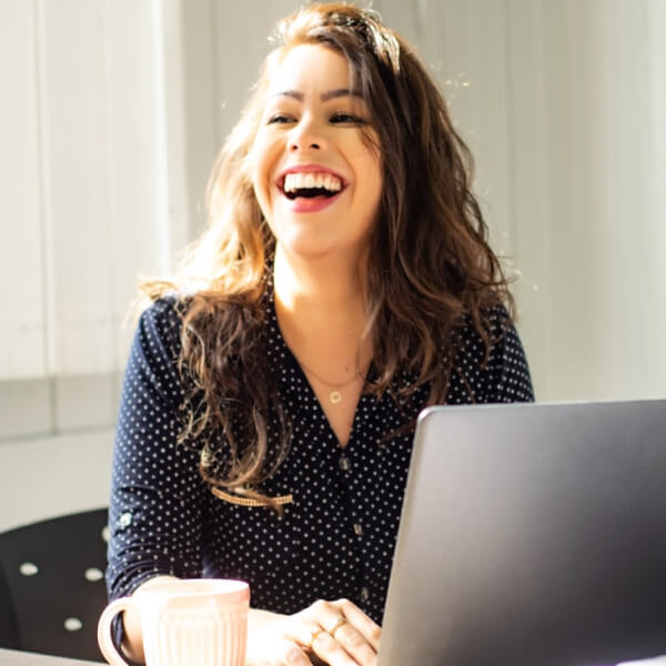 woman smiling while using her laptop